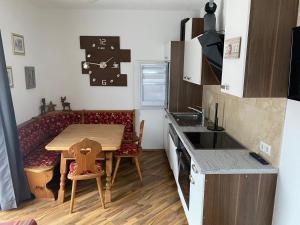 a small kitchen with a wooden table and a dining room at Appartement Klein Tirol in Pettneu am Arlberg