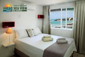 um quarto com uma cama e vista para o oceano em Residence Village em Natal