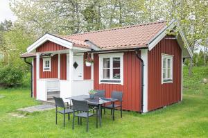 a red and white shed with a table and chairs at KustCamp Ekön in Gryt