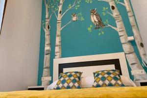 a bedroom with a mural of trees and owls at Cumbres de los Picos Apartamento "Buhos" in Poo de Cabrales