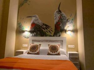 Poo de Cabrales的住宿－Cumbres de los Picos Apartamento Treparriscos，卧室配有一张床铺,墙上有两只鸟