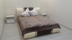 1 dormitorio con 1 cama grande y 2 mesitas de noche en Будинок для гостей по вул. Шевченка, en Beregovo