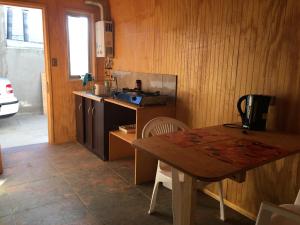 a kitchen with a wooden table and a table and a stove at Cabañas en Algarrobo Norte in Algarrobo