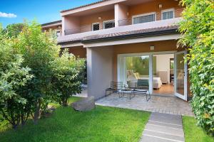 a view of a house with a patio and a garden at Chia Laguna - Hotel Village in Chia