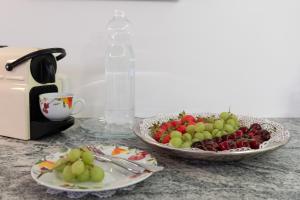 dos platos de fruta en un mostrador junto a una cafetera en Business Apartment, en Schwarzach