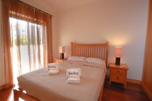 1 dormitorio con 1 cama con 2 toallas en Apartamento Corcovada - By Bedzy, en Albufeira