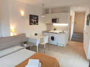 a bedroom with a bed and a kitchen with a table at Apartaments Fonda Comerç in Torroella de Montgrí