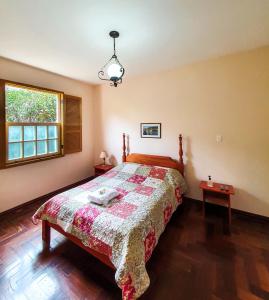 um quarto com uma cama e uma janela em Pousada Quinta Do Conde em Tiradentes