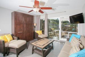 a living room with a couch and a ceiling fan at Kahana Sunset #B7 Home in Kahana