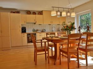 une cuisine avec une table et des chaises en bois ainsi qu'une salle à manger dans l'établissement Secret Garden, à Müllheim