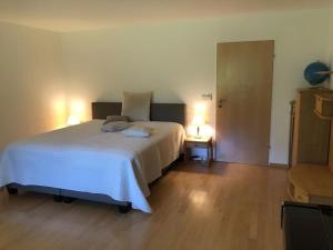 - une chambre avec un lit blanc et deux lampes dans l'établissement Secret Garden, à Müllheim