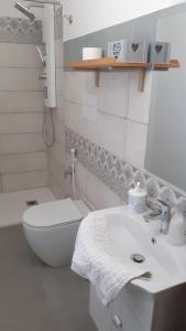 Baño blanco con aseo y lavamanos en Villa Sabri, en San Leone