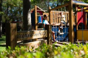 a park with a playground with people on a train at Green Village Eco Resort in Lignano Sabbiadoro