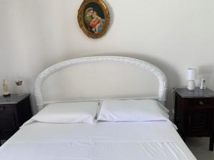 1 dormitorio con 1 cama blanca y 2 mesitas de noche en Villa Sabri, en San Leone
