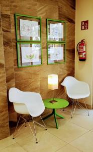 dwa białe krzesła i zielony stół w pokoju w obiekcie La City Mercado w Alicante