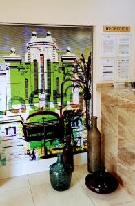 tre vasi seduti sul pavimento di fronte a un dipinto di La City Mercado ad Alicante