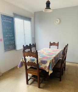 a dining room table with two chairs and a chalkboard at Alojamiento en el centro de Salta - Casaguemessalta in Salta +39 photos