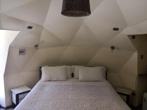 um quarto com uma cama grande num sótão em San Pedro Domos em San Pedro de Atacama