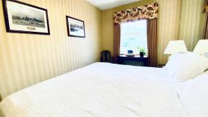 1 dormitorio con cama blanca y ventana en Shawnee Inn and Golf Resort, en East Stroudsburg