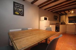 a room with a table and chairs and a kitchen at Malvern House in Banbury