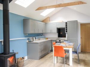 a kitchen with a table and a stove at The Cosy Cowshed in Axminster