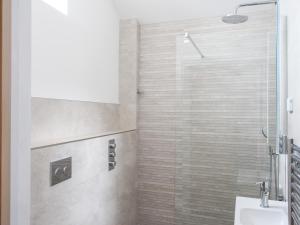 a bathroom with a shower with a glass door at The Cosy Cowshed in Axminster