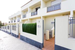 a building with a hedge on the side of it at Oasis Fañabe Townhouse in Adeje