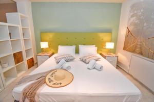 a bedroom with a large white bed with a hat on it at Villa Marinos in Kavos +116 photos