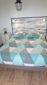 ein Schlafzimmer mit einem Bett mit einer Decke darauf in der Unterkunft Le bélouga in Sangatte