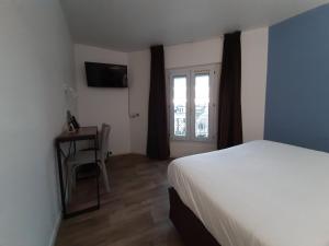 Un dormitorio con una cama y una ventana y una silla. en Le Royalty, en Angers