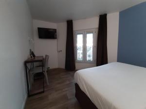 1 dormitorio con cama, ventana y silla en Le Royalty, en Angers