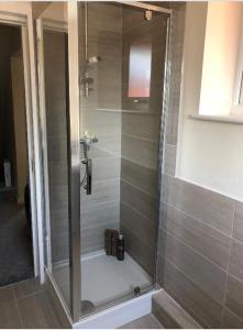 a shower with a glass door in a bathroom at M60 Modern Studio Appartment with free parking in Denton