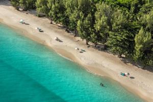 an overhead view of a beach with people in the water at Constance Tsarabanjina - All Inclusive in Nosy Be