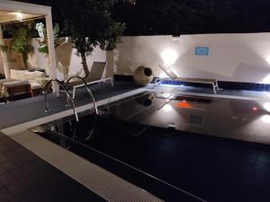 ein Schwimmbad mit Lichtern in einem Haus in der Nacht in der Unterkunft Aparthotel Masseria Villa Marchesi in Taranto