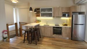 a kitchen with wooden cabinets and a stainless steel refrigerator at Skinari Apartments in Monolia