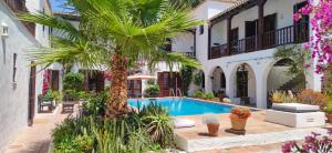 un patio con piscina y palmeras en El Molino Estepona en Estepona