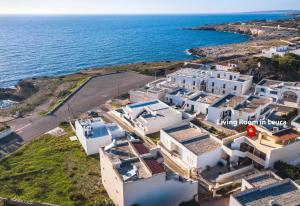 an aerial view of a cluster of white buildings next to the ocean at Living Room in Leuca in Leuca