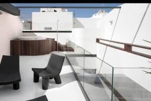 balkon z 2 krzesłami i szklaną poręczą w obiekcie Ocean Space Lanzarote w mieście Punta de Mujeres
