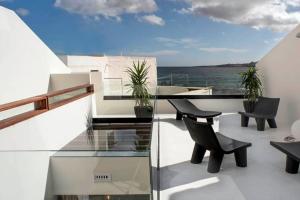 balkon ze stołem i krzesłami oraz oceanem w obiekcie Ocean Space Lanzarote w mieście Punta de Mujeres