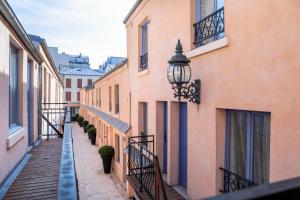 an alley in a city with buildings and a street light at Hotel De L'Horloge in Paris