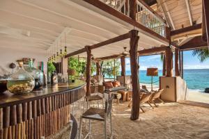 a bar in a room with a view of the ocean at Constance Tsarabanjina - All Inclusive in Nosy Mitsio