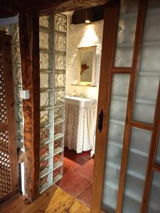 baño con lavabo y baño con estanterías de cristal en casa rural decerca, en Arcones