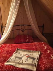 Schlafzimmer mit einem Bett mit einer roten Bettdecke in der Unterkunft Romantic Eco Holiday Home in Píkovice