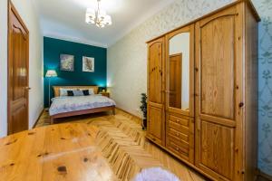 a bedroom with a bed and a large wooden cabinet at Затишна квартира на Майдані Незалежності in Kyiv