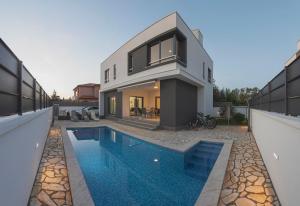 una casa con piscina frente a una casa en Villa Sunce, en Pula