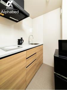 a kitchen with a sink and a stove at ALPHABED INN Fukuoka Ohori Park - Vacation STAY 06391v in Fukuoka