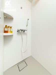 y baño blanco con ducha y lavamanos. en ALPHABED INN Fukuoka Ohori Park - Vacation STAY 06391v en Fukuoka