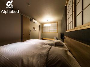 2 camas en una habitación pequeña con ventana en ALPHABED INN Fukuoka Ohori Park - Vacation STAY 06391v en Fukuoka
