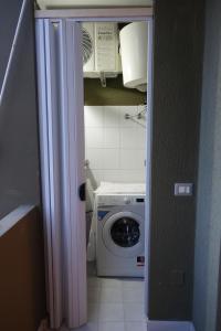 a kitchen with a washing machine and a microwave at Flamingo view in Quartu SantʼElena