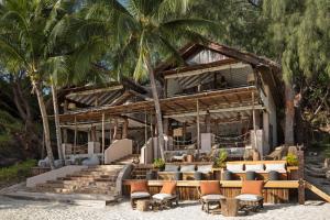 - un complexe sur la plage avec des chaises et des palmiers dans l'établissement Constance Tsarabanjina - All Inclusive, à Nosy Mitsio